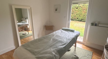 Salle de soins MaPhyto à Grande-Synthe avec table de massage près de la fenêtre.