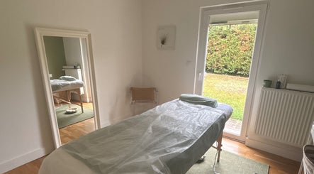 Salle de massage lumineuse à MaPhyto, Grande-Synthe, Hauts-de-France, FR avec table de soin et vue sur jardin.