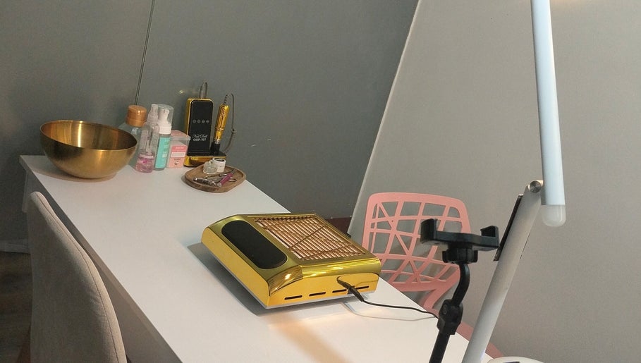 Mesa de trabajo en Jack Nailsmx, Ciudad De México, MX, con equipo dorado y productos de belleza.