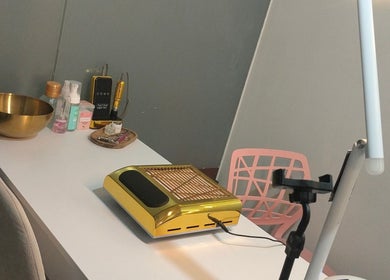 Mesa de trabajo en Jack Nailsmx, Ciudad De México, MX, con equipo dorado y productos de belleza.
