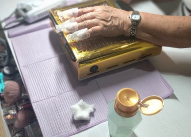 Manicura en proceso en Jack Nailsmx, Ciudad De México, con lámpara UV dorada para secado de uñas.