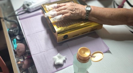 Manicura en proceso en Jack Nailsmx, Ciudad De México, con lámpara UV dorada para secado de uñas.
