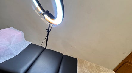 Luxurious treatment bed at The Beauty Spot, Jeddah, SA, with a glowing ring light for a relaxing experience.
