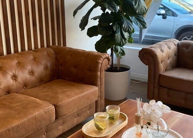 Cozy lounge area at Black Swan Asian Massage Hobart, Hobart, Tasmania, AU with plush sofas and a leafy plant.