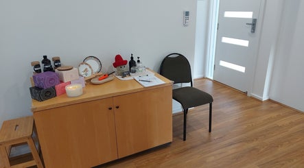 Calm welcoming area at Shu's Massage Therapy In Mernda, Melbourne, Victoria, AU with a decor cabinet and a chair.