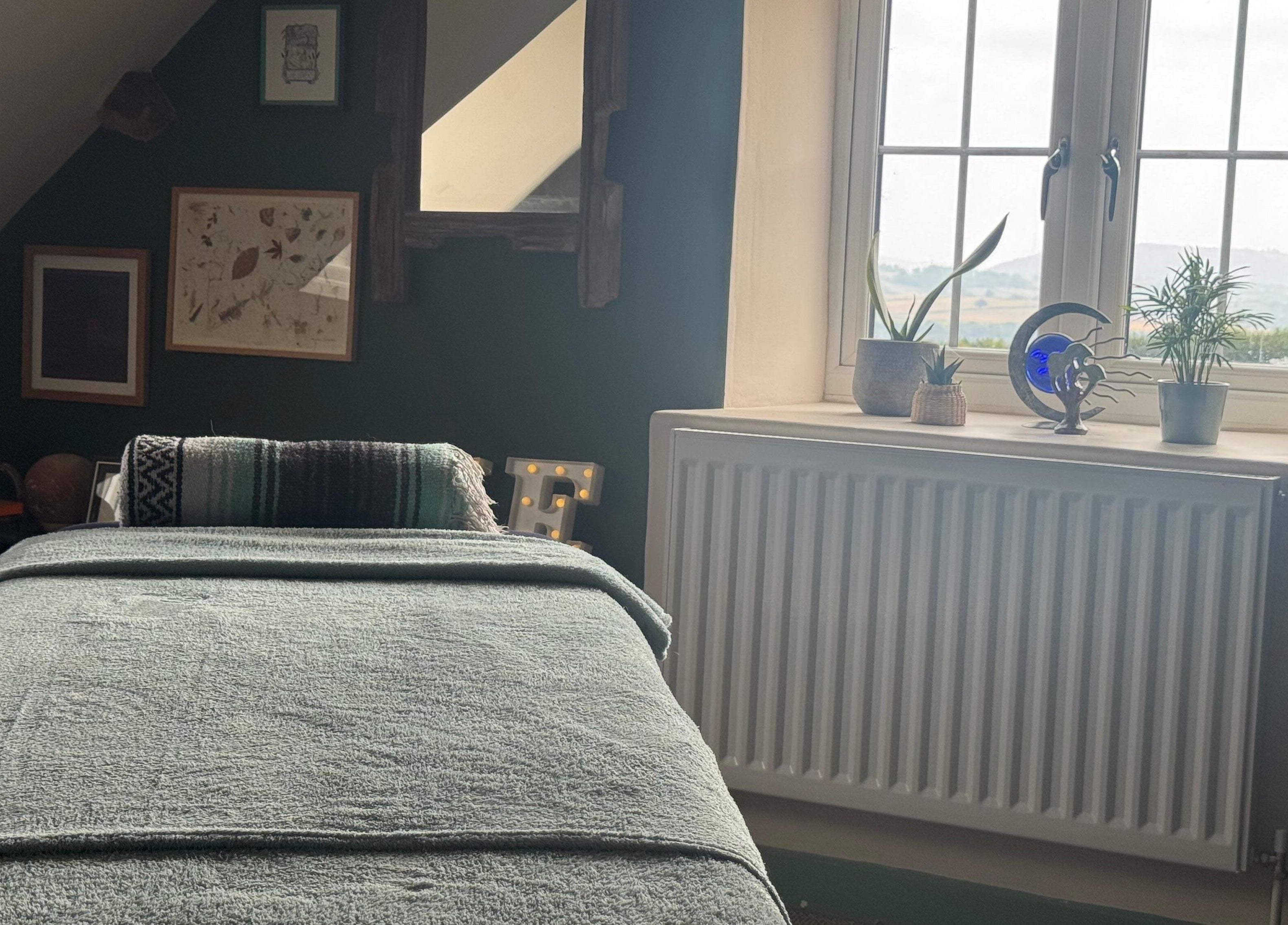 Peaceful massage room at Mountain Flow Massage, Clyro, Wales, GB with a cozy table and decorative plants.