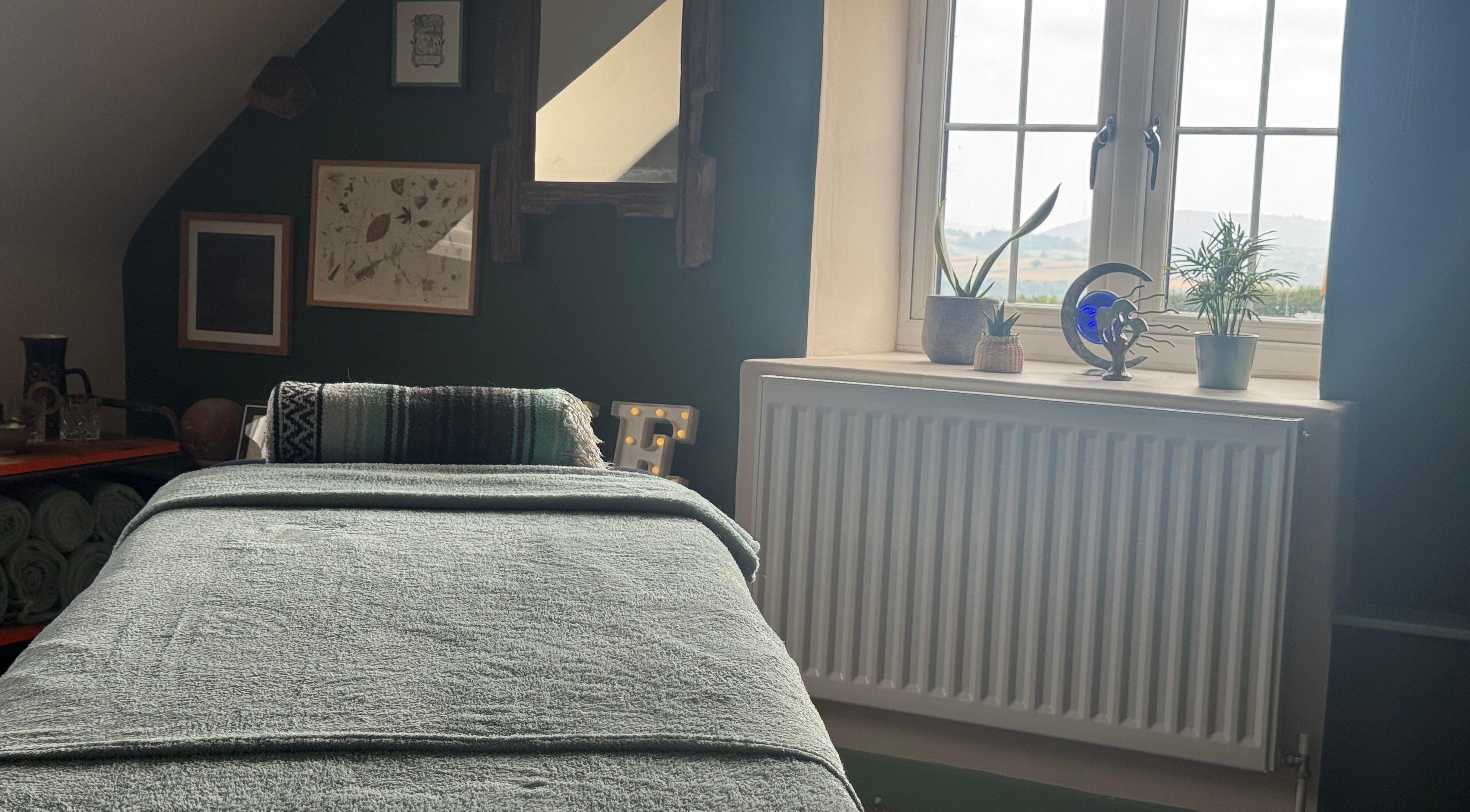 Peaceful massage room at Mountain Flow Massage, Clyro, Wales, GB with a cozy table and decorative plants.