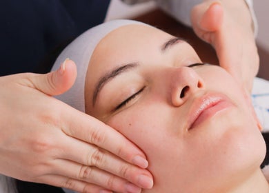 Tratamiento facial en Vela Clinic en Barcelona, Cataluña, ES, mostrando manos realizando un masaje relajante.