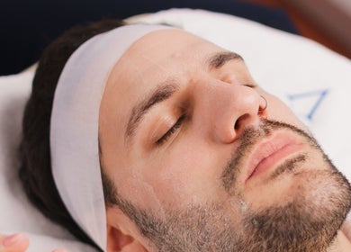 Hombre disfrutando de un tratamiento facial en Vela Clinic, Barcelona, Cataluña, ES.