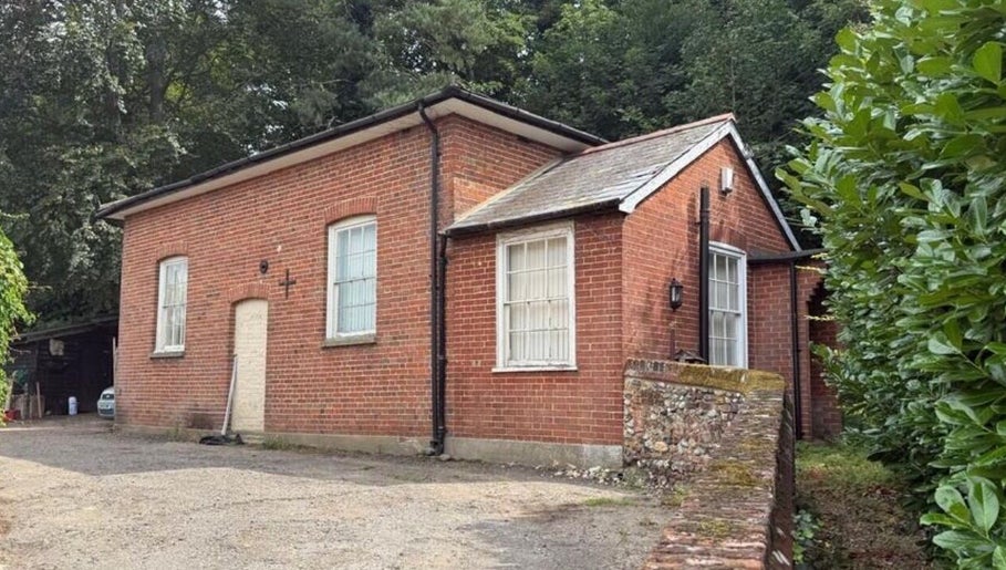 The Beauty Ritualist | Wellness Clinic, a quaint brick building in Ipswich, England, GB surrounded by lush greenery.
