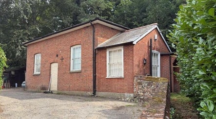 The Beauty Ritualist | Wellness Clinic, a quaint brick building in Ipswich, England, GB surrounded by lush greenery.