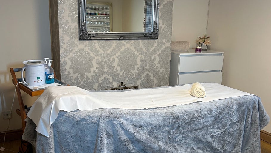 Cozy treatment room at Homespa Nails & Beauty, Saint Columb, England showcasing a massage bed and elegant decor.