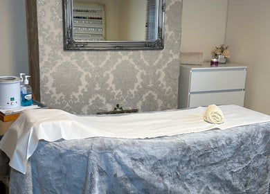 Cozy treatment room at Homespa Nails & Beauty, Saint Columb, England showcasing a massage bed and elegant decor.