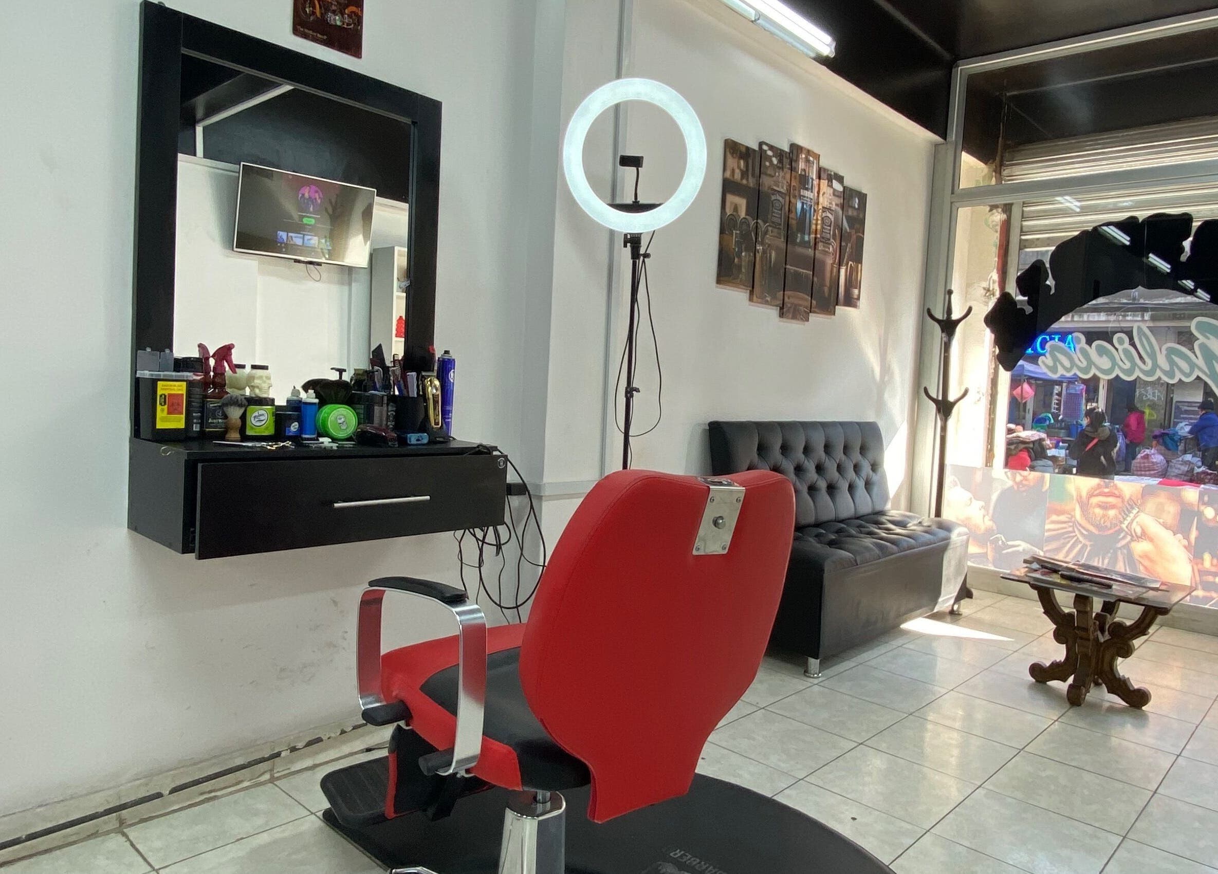 Interior de Barberia Galicia en Santiago, Región Metropolitana, CL, mostrando un sillón elegante y estación de trabajo.