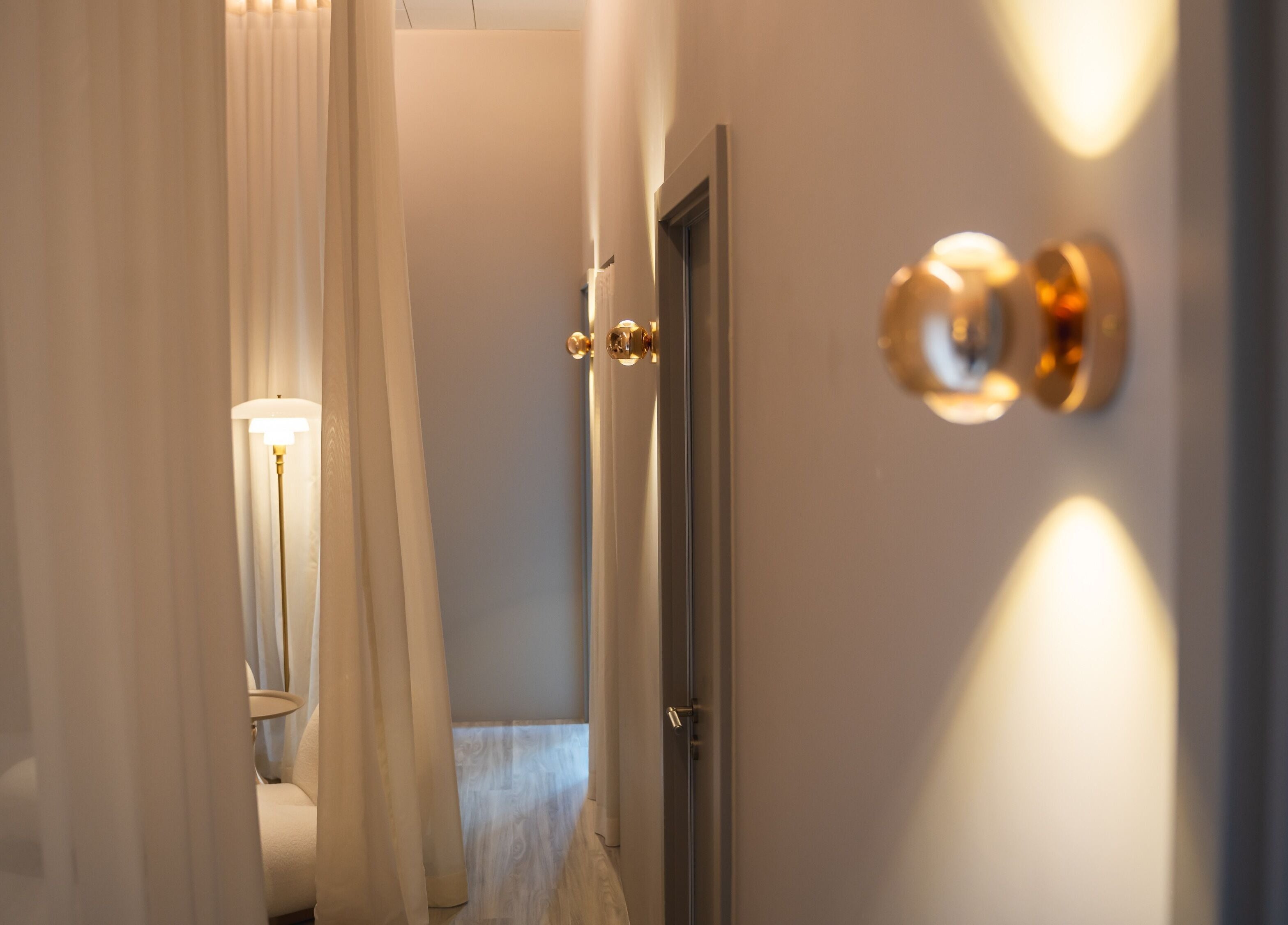 Time Off Beauty 的宁静走廊，位于香港 Fortress Hill，设有柔和灯光和优雅的白色窗帘。