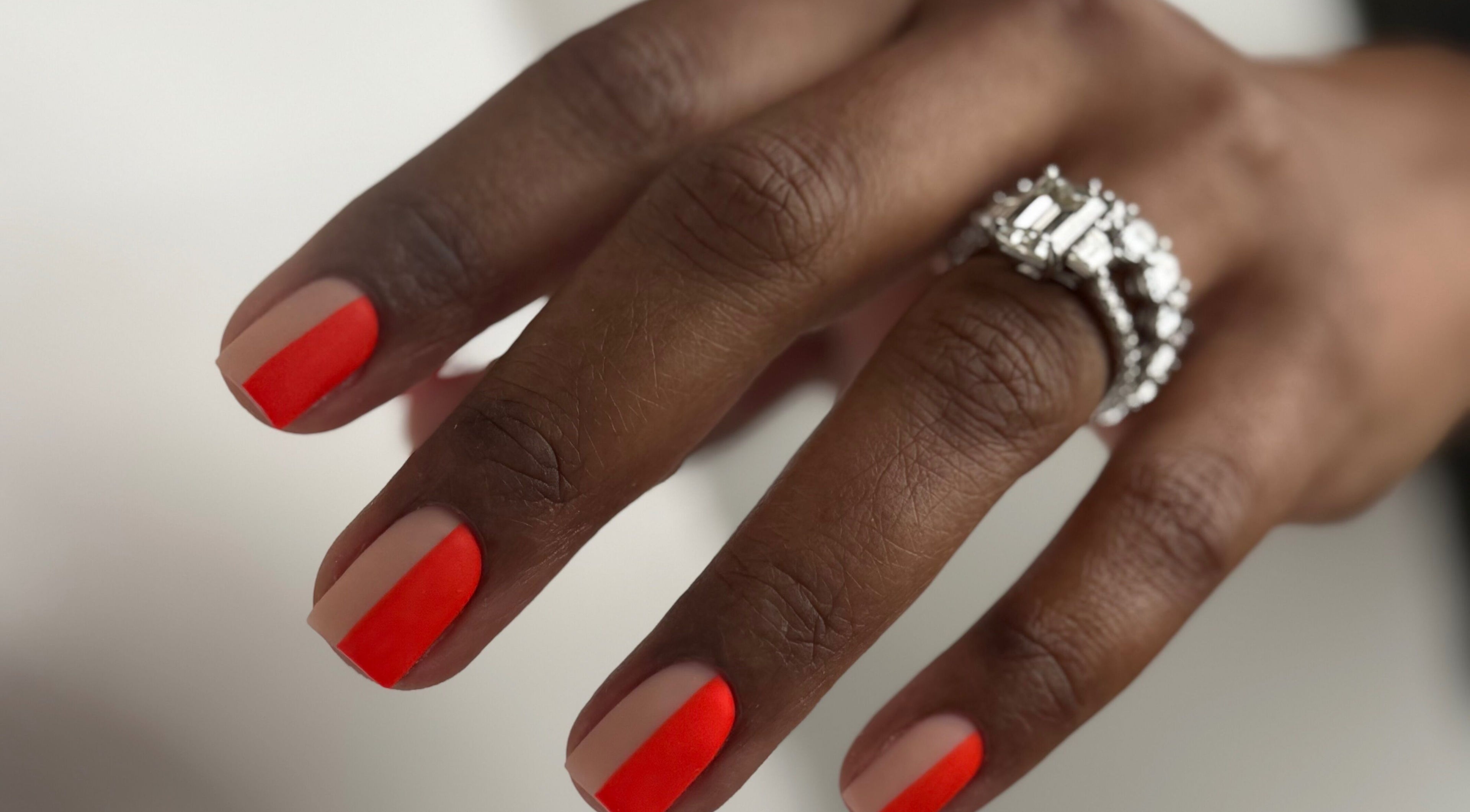 Stylish red-tipped nails with diamond ring at M Beauty Nails, Chicago, Illinois, US.