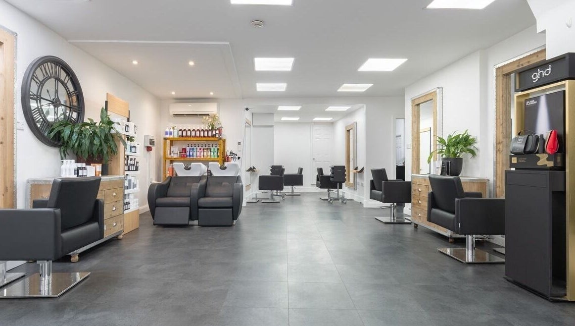 Modern salon interior with sleek black chairs at Hairbykaty, Sale, England, GB.