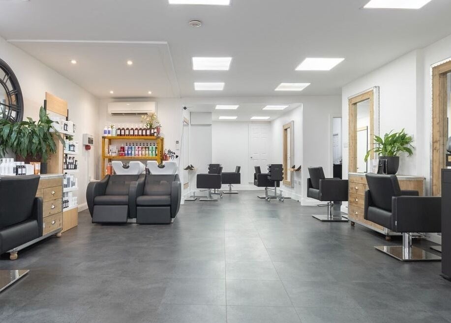 Modern salon interior with sleek black chairs at Hairbykaty, Sale, England, GB.