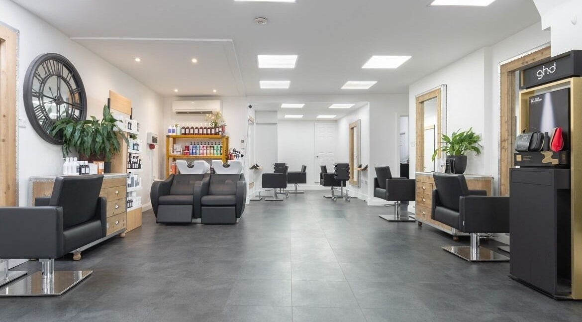Modern salon interior with sleek black chairs at Hairbykaty, Sale, England, GB.