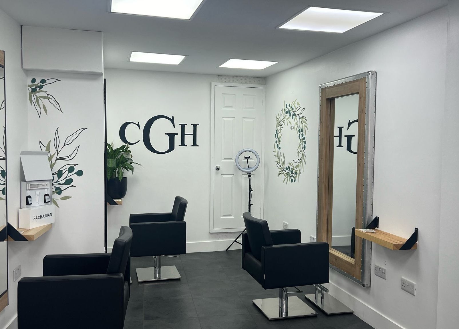 Modern salon interior at Hairbykaty, Sale, England, GB with sleek black chairs and stylish mirrors.