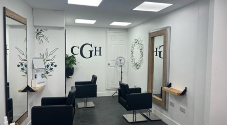 Modern salon interior at Hairbykaty, Sale, England, GB with sleek black chairs and stylish mirrors.