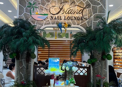 Entrance of Island Nail Lounge in Houston, Texas, US with palm trees and elegant decor.