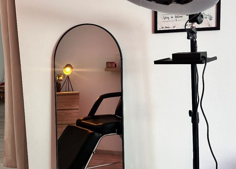 Espelho e cadeira no salão Femmi.Studio em Lagos, Faro, PT, destacando ambiente acolhedor e moderno.