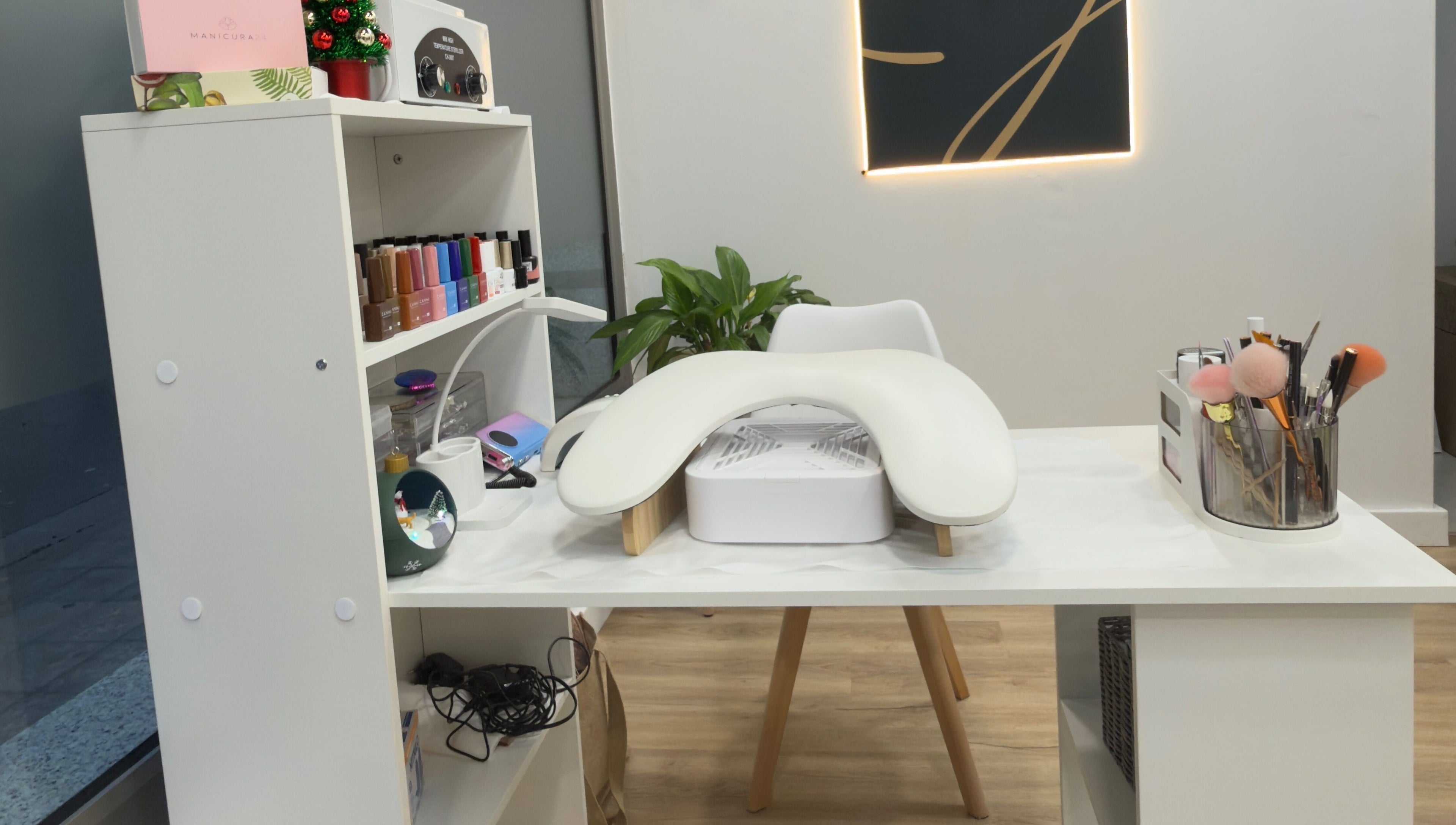 Mesa de manicura elegante en Jhovana Hair Studio, L'escala, Catalunya, ES, con esmaltes y herramientas.