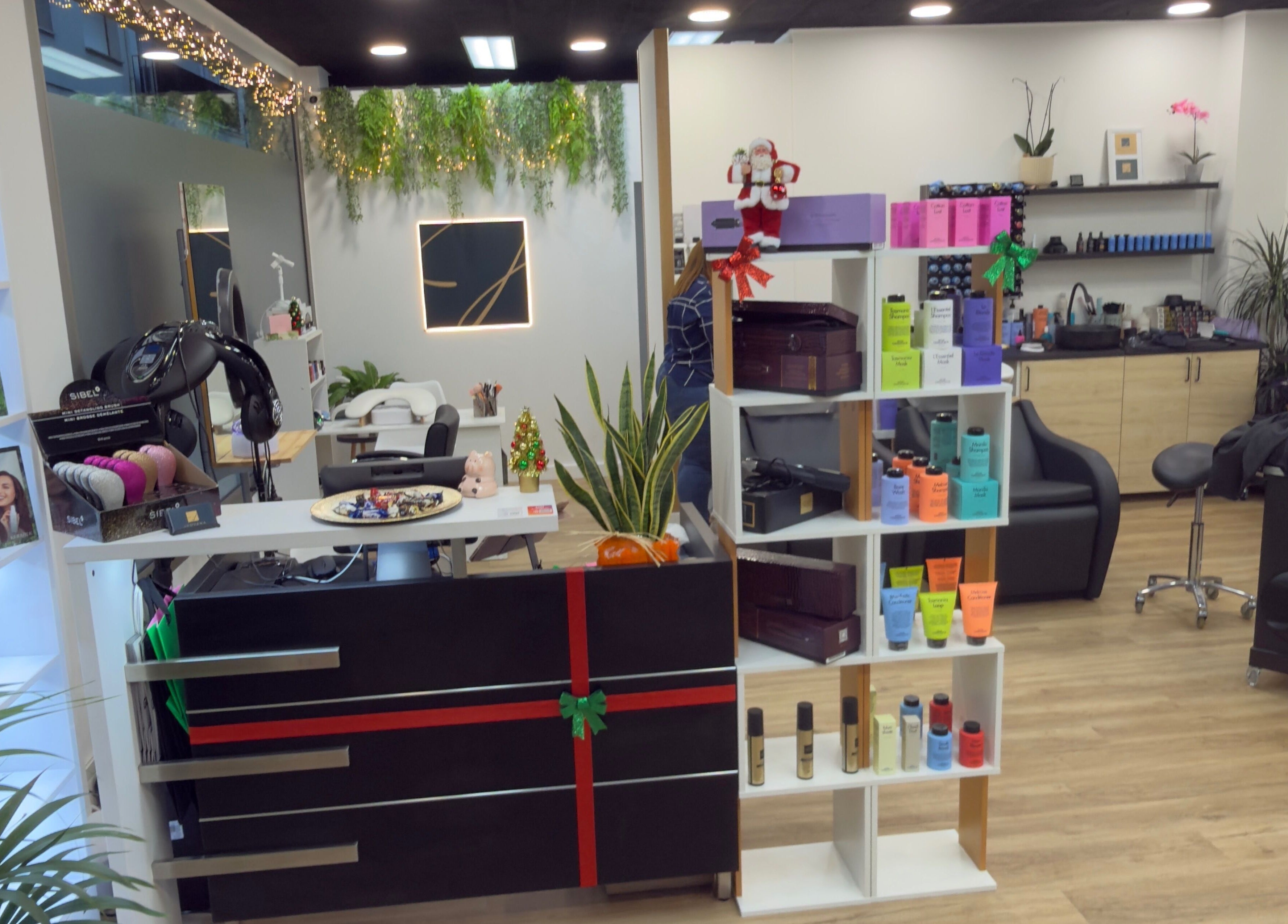 Interior moderno de Jhovana Hair Studio en L'escala, Catalunya, ES, mostrando productos de belleza y decoración elegante.