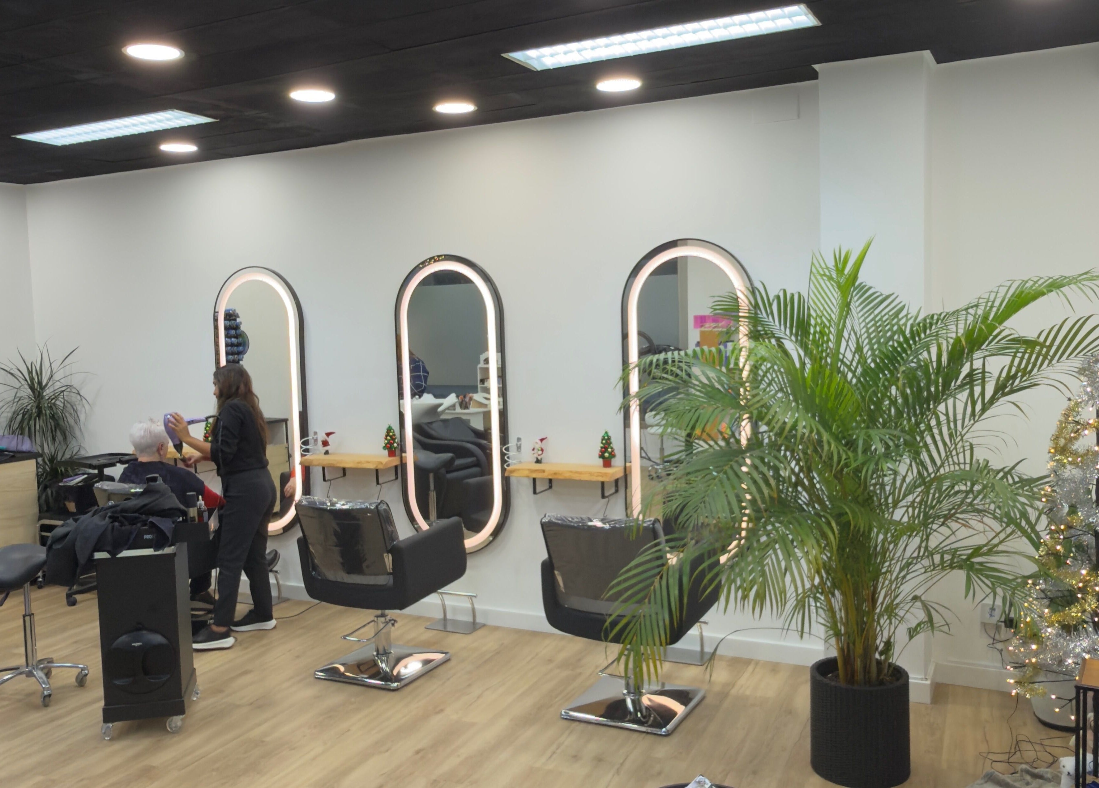 Interior de Jhovana Hair Studio en L'escala, Catalunya, ES, con sillas estilizadas y plantas decorativas.