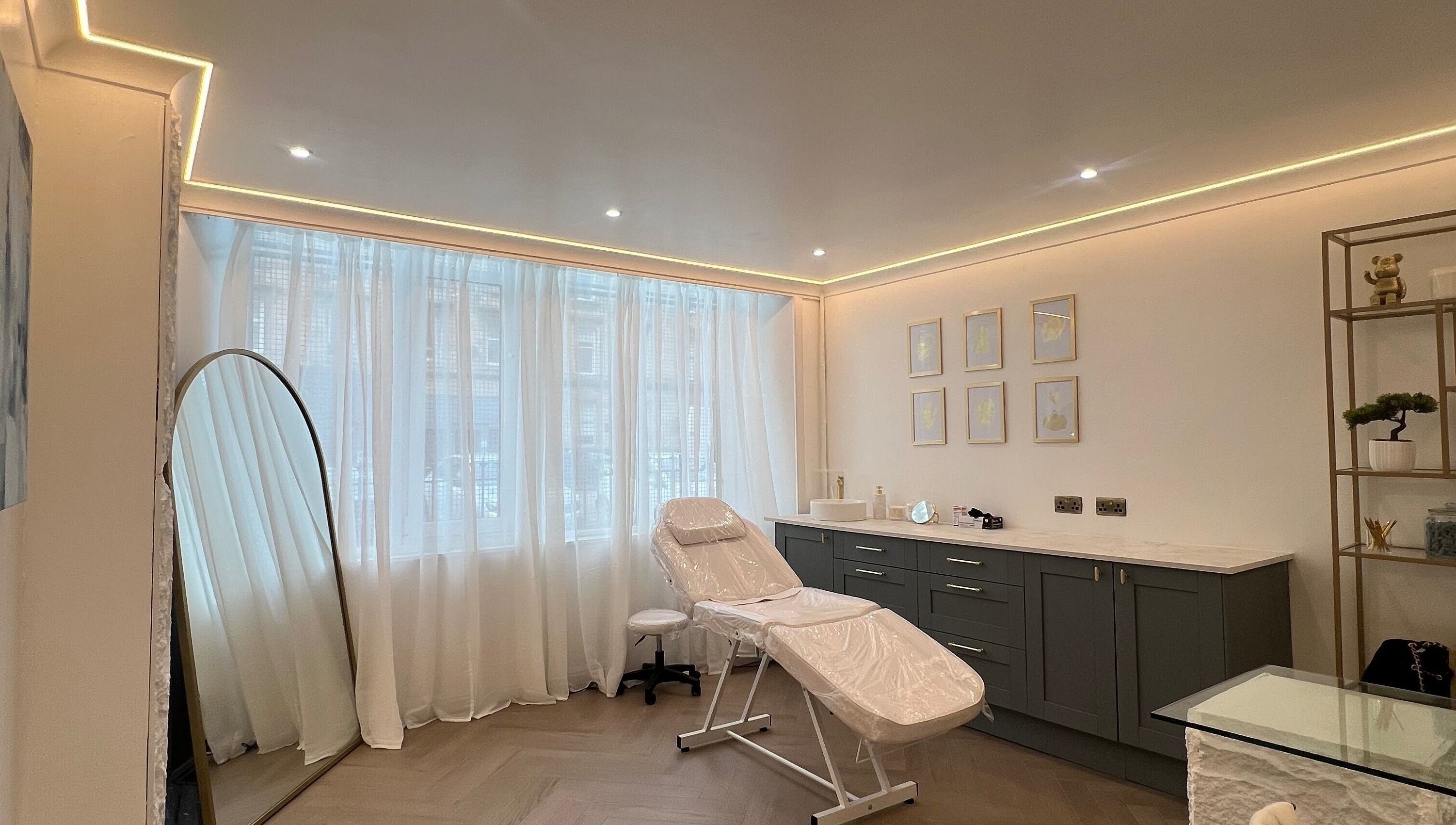 Relaxing treatment room at HM Advanced Aesthetics in Glasgow, Scotland, GB with modern decor and natural light.