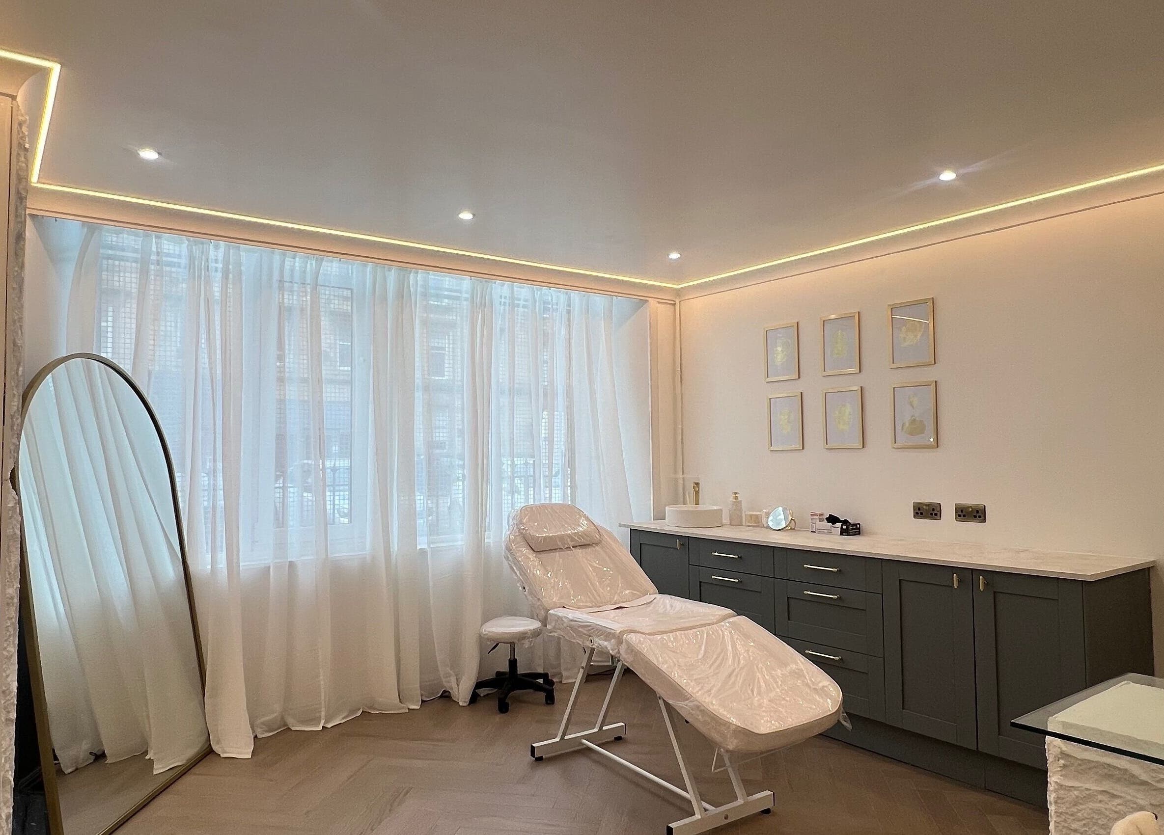 Relaxing treatment room at HM Advanced Aesthetics in Glasgow, Scotland, GB with modern decor and natural light.