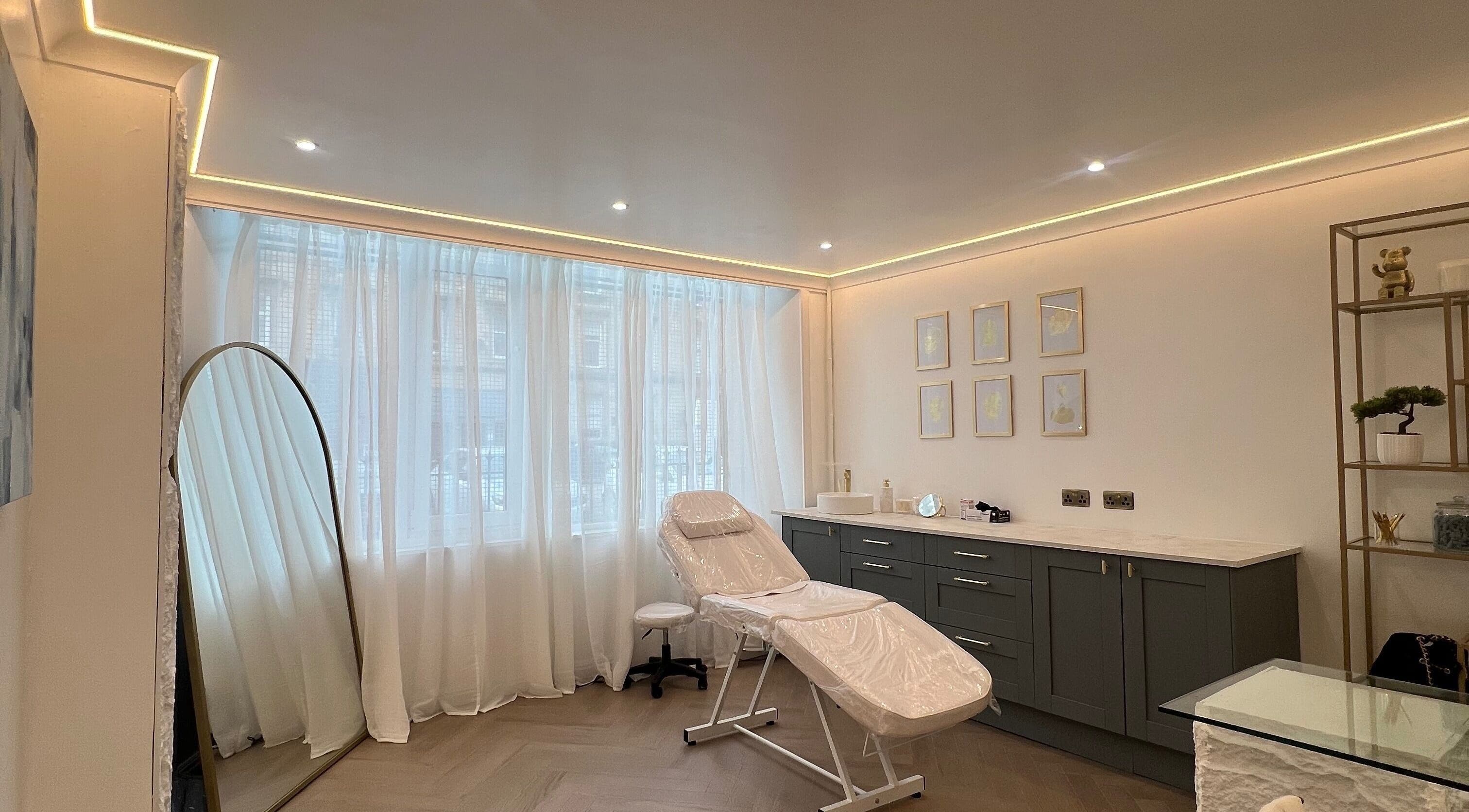 Relaxing treatment room at HM Advanced Aesthetics in Glasgow, Scotland, GB with modern decor and natural light.