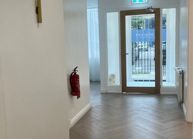 Chic hallway entrance at HM Advanced Aesthetics in Glasgow, Scotland, GB, featuring wood floor and glass door.