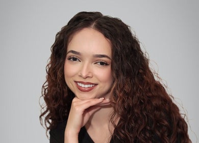 Radiant young woman smiling, showcasing beauty services at Glow & Grace Esthetics, Calgary, Alberta, CA.