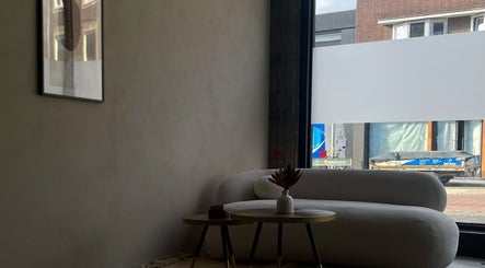 Stijlvolle loungehoek bij Claws by J in Geleen, Limburg, NL met moderne bank en kunstwerk.