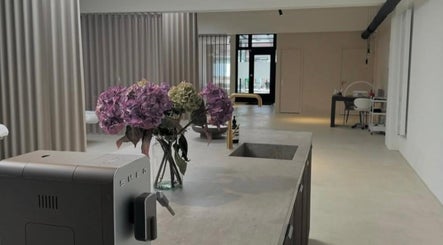 Moderne schoonheidssalon Claws by J in Geleen, Limburg, NL met stijlvolle inrichting en bloemen op tafel.