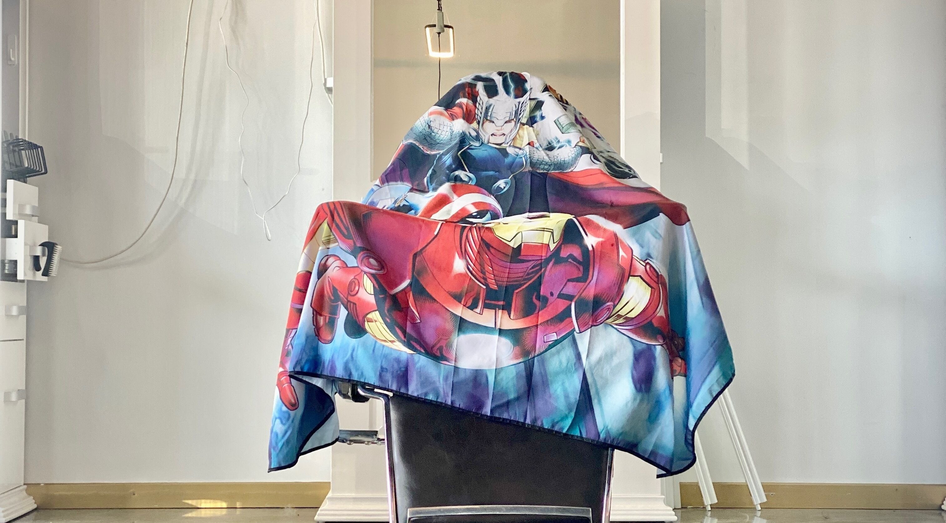 Chair at Non Surgical Hair Replacement in Melbourne, Victoria, AU adorned with a superhero-themed cape.