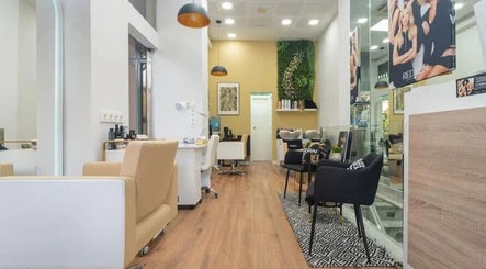 Interior luminoso de Adrián Blondé Estudio en Madrid, Comunidad De Madrid, ES, mostrando sillas beige y verde.