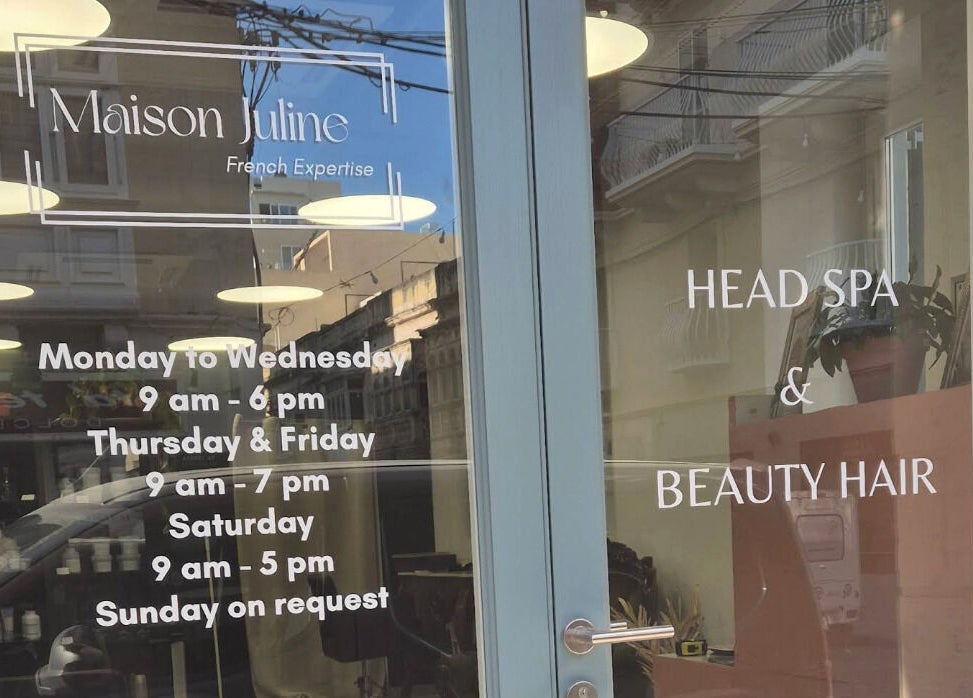 Maison Juline entrance displays hours and services at Il-Gzira, MT, highlighting beauty and wellness offerings.