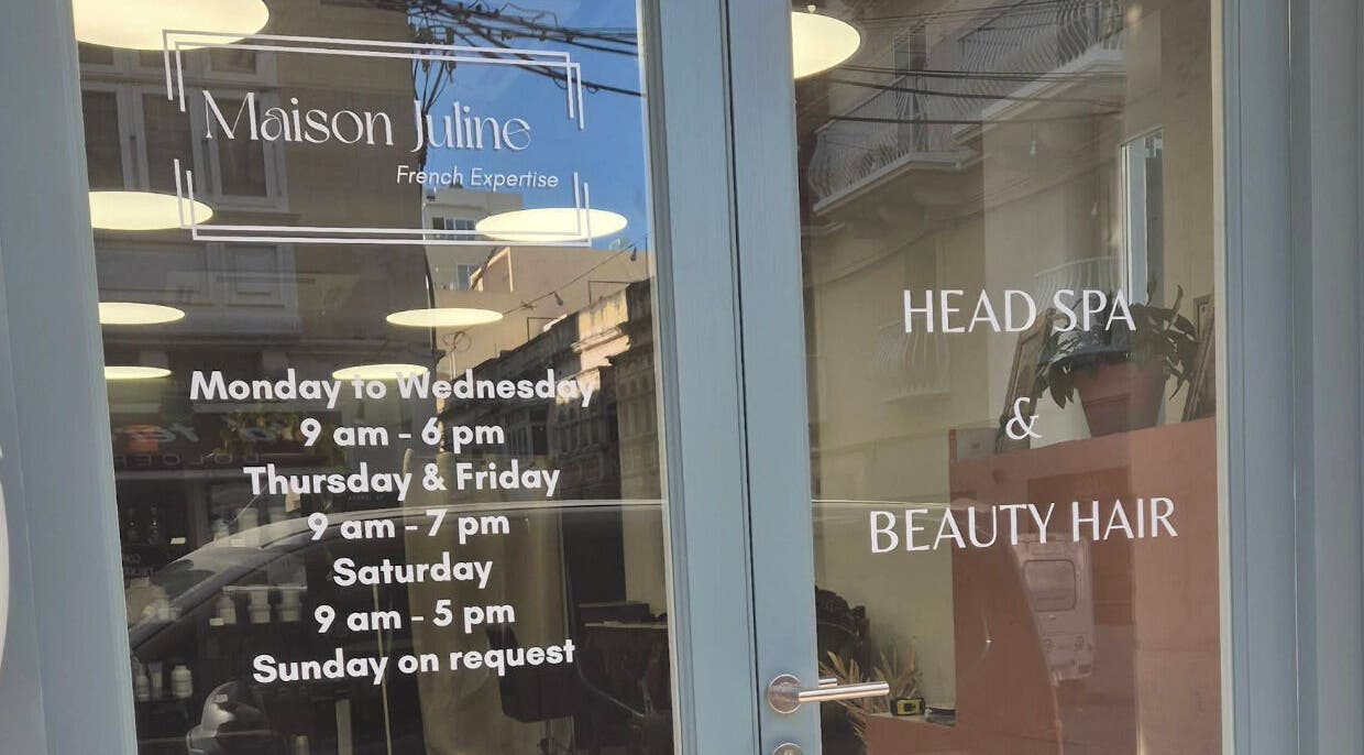 Maison Juline entrance displays hours and services at Il-Gzira, MT, highlighting beauty and wellness offerings.