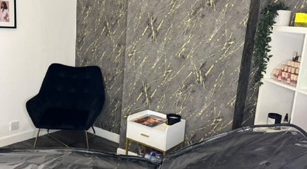Elegant corner at Vasilica Manchester Aesthetics, Dukinfield, England, featuring a chair and marble wall.