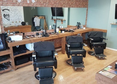 Stylish interior of Cutthroat Jacks Edgeley, Stockport, England, GB, showcasing modern barber chairs and sleek decor.