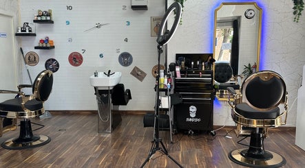 Interior elegante de Barber Shop Amin en Madrid, Comunidad De Madrid, ES con sillas de peluquería y espejo iluminado.