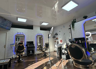 Interior de Barber Shop Amin en Madrid con espejos iluminados y sillas elegantes, Comunidad De Madrid, ES.