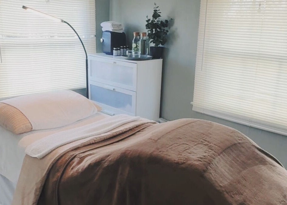 Tranquil massage room at Root and Remedy Wellness in Purleigh, England, GB, with cozy bed and ambient lighting.