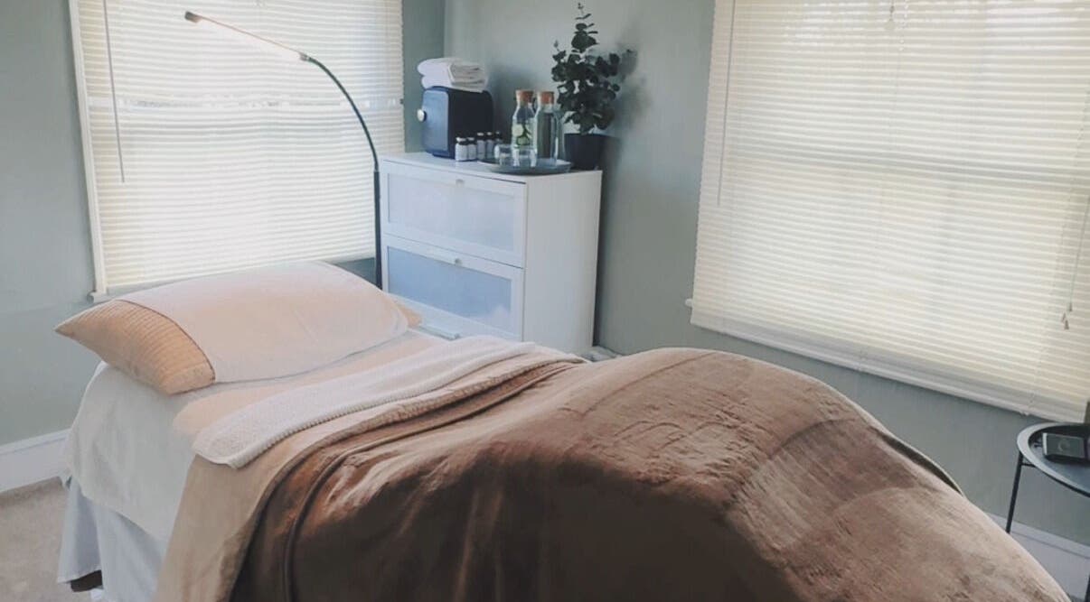 Tranquil massage room at Root and Remedy Wellness in Purleigh, England, GB, with cozy bed and ambient lighting.