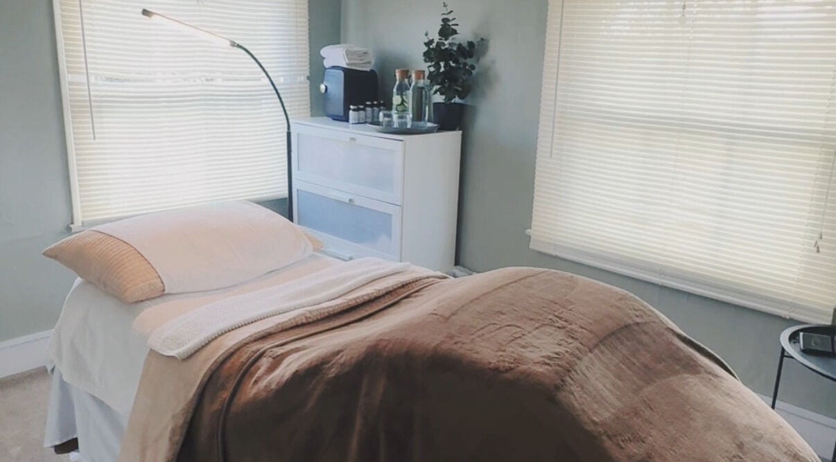 Tranquil massage room at Root and Remedy Wellness in Purleigh, England, GB, with cozy bed and ambient lighting.