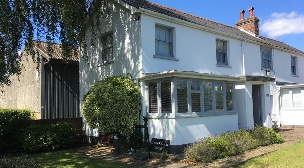 Exterior of Root and Remedy Wellness, a serene white building in Purleigh, England, GB for relaxation and healing.