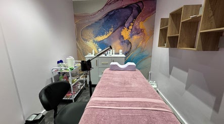 Spa treatment room at Blush and Buff, Cape Town, Western Cape, ZA, with artistic wall decor and a plush bed.